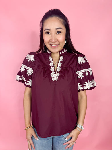 burgundy v neck top with embroidered puff sleeves