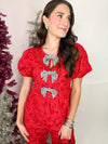 red top with red sequin bows 